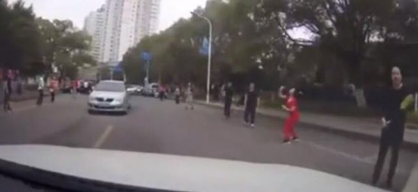 太危险！晨练者横跨马路打羽毛球 网友：简直不要命